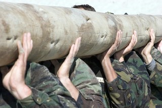 教育军事多个士兵共同抬起一根木桩宣传背景图片